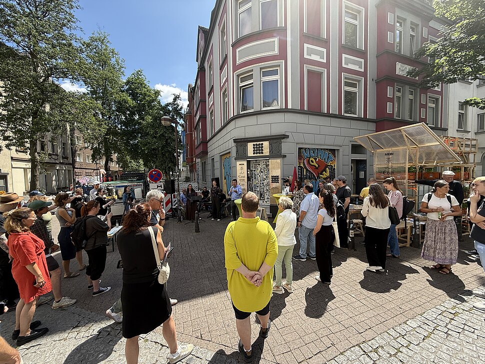 Menschen stehen versammelt vor der Pop-Up-IGA in Duisburg bei der Eröffnungsfeier.