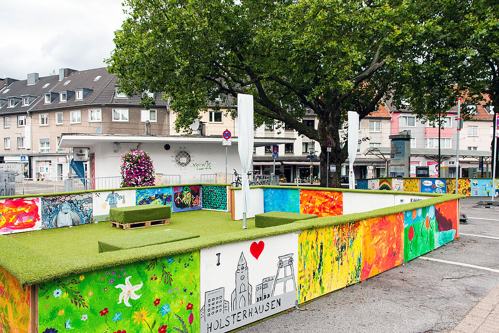Das Foto zeigt den Gemarkenplatz in der Stadt Essen, auf dem eine farbenfrohe Installation aufgebaut wurde. 