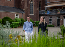 Zwei junge Menschen laufen durch den Garten von St. Bernardin in Sonsbeck, altes Klostergebäude im Hintergrund