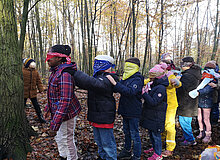 Grünes Klassenzimmer Duisburg Grundschulklinder stehen mit verbundenen Augen hintereinander vor einem Baum