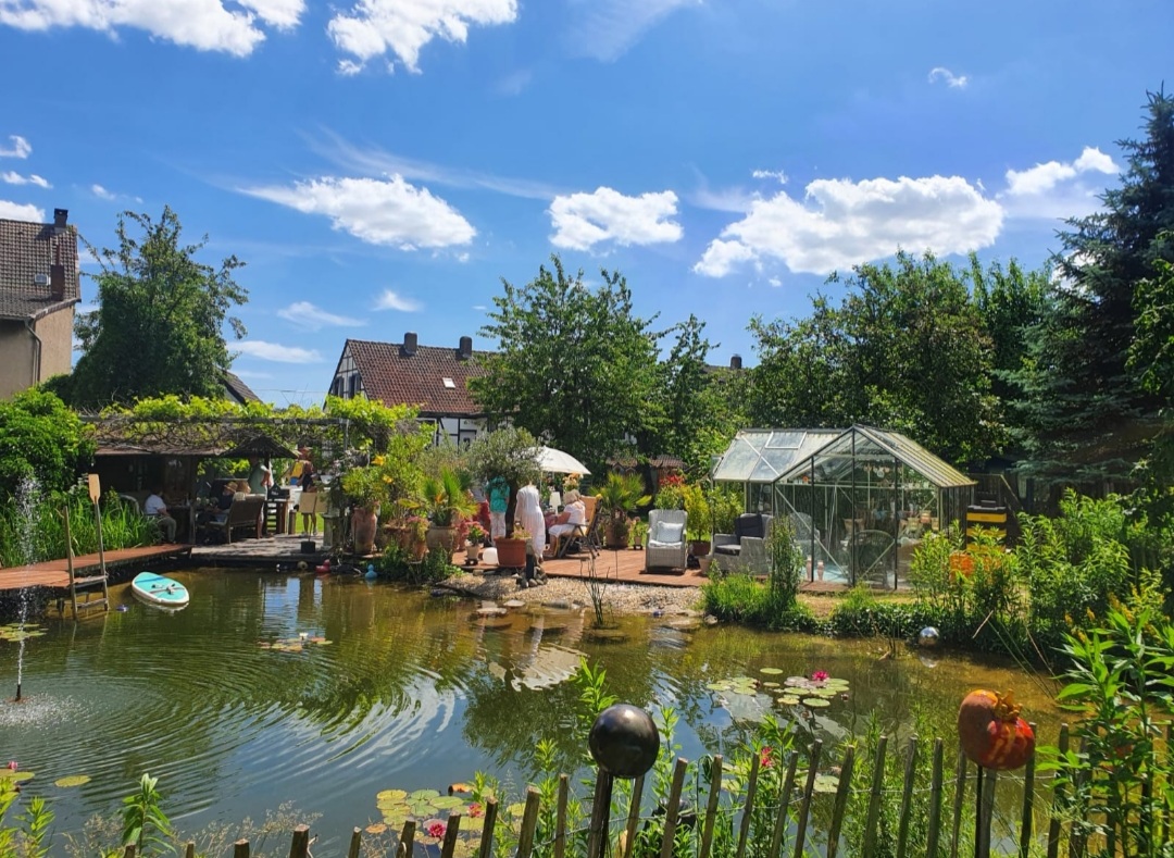Blick vom Ende des Garten zum Haus über den Schwimmteich
