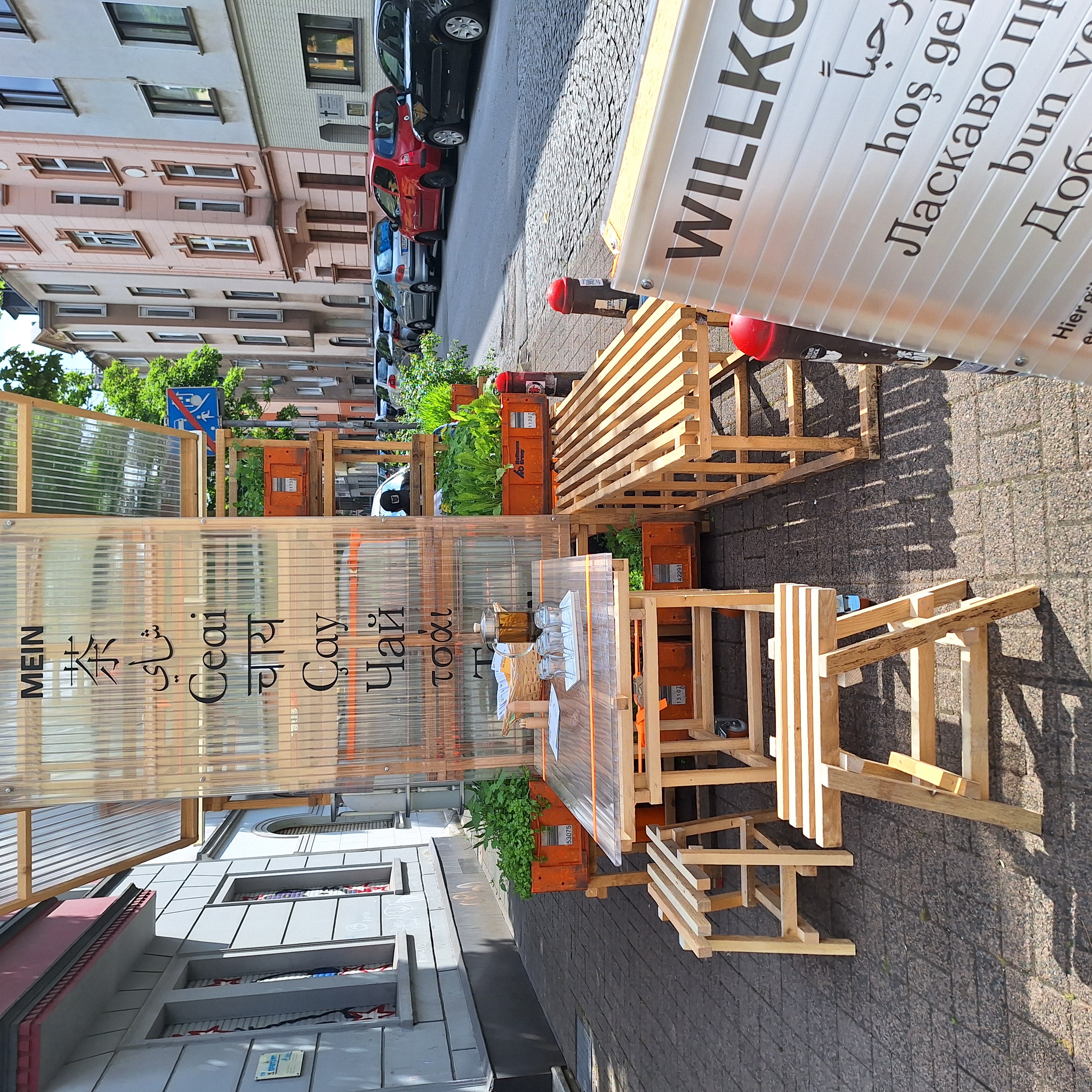 Außenbereich des Pop-Up-IGA Duisburg-Hochfeld mit Tisch, zwei Hockern und Infomaterial