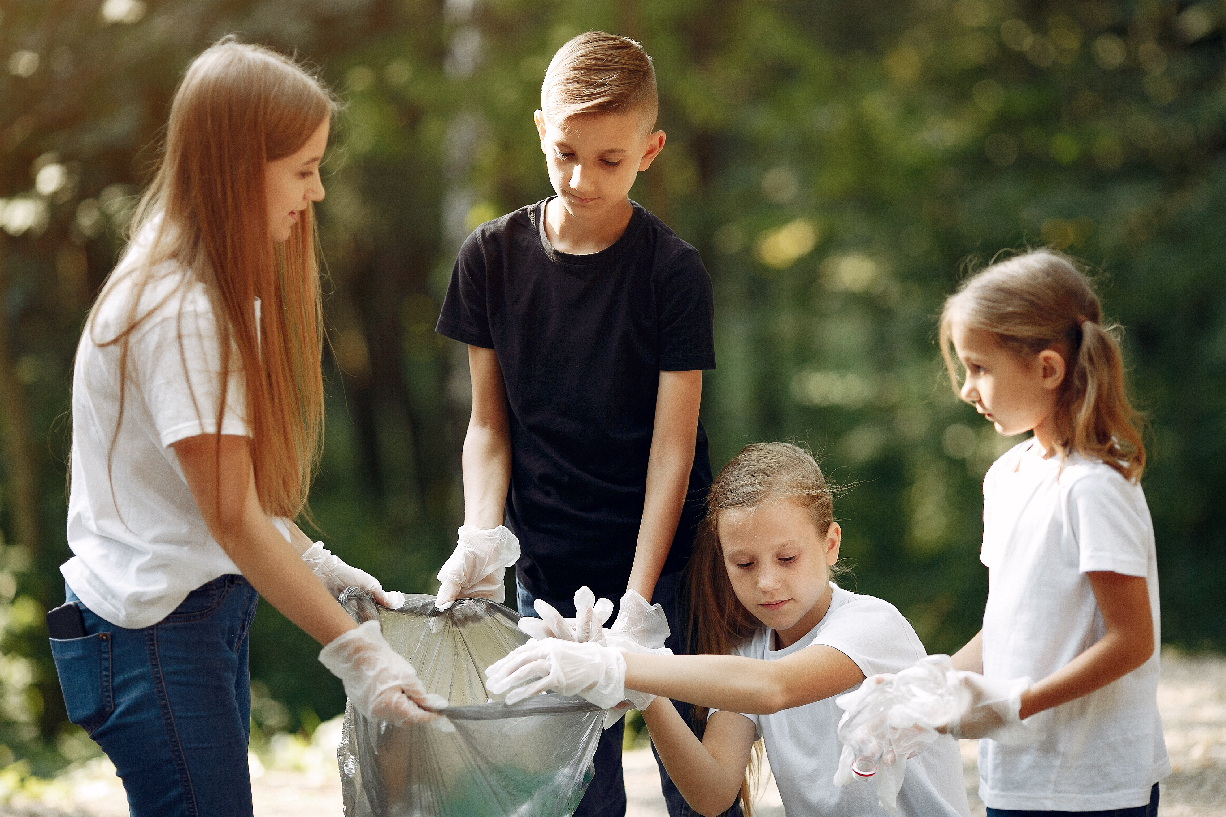 Kinder sammeln gemeinsam Müll im Park Kinder sammeln gemeinsam Müll im Park